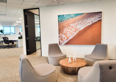 The lobby of the American Heritage Lending office with four chairs one center table and with a picture of the shore on the wall