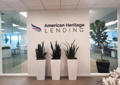 The American Heritage Lending office, decorated with plants and the logo of the company on a white wall